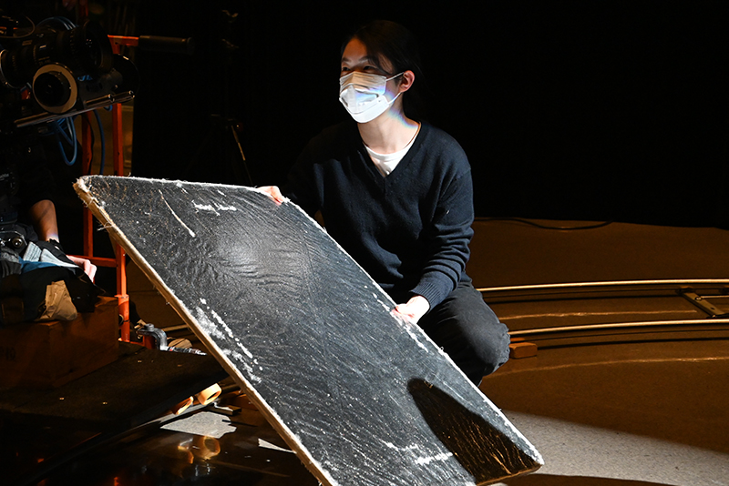 演者の顔に影ができないように、レフ板を当てています。