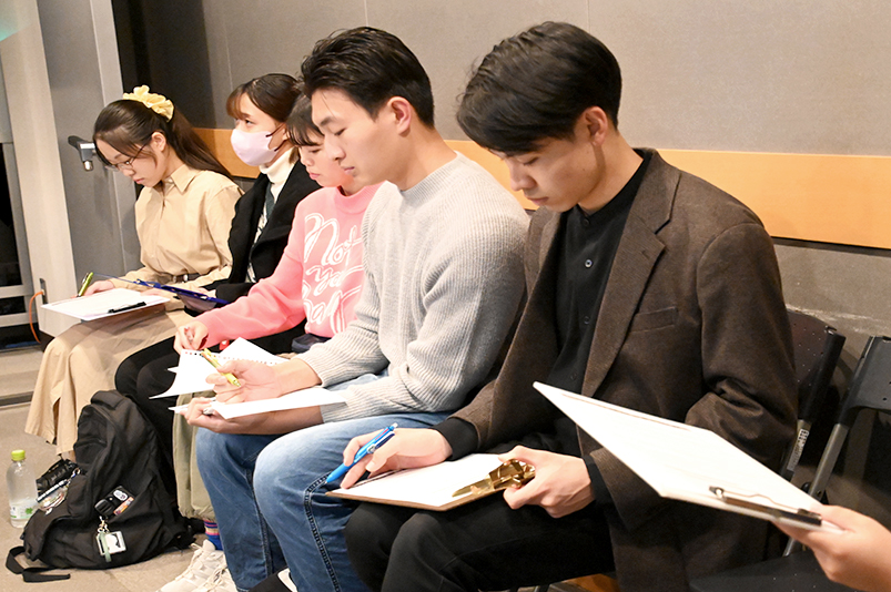 三村さんからのアドバイスに熱心にメモを取り組む学士学生たち