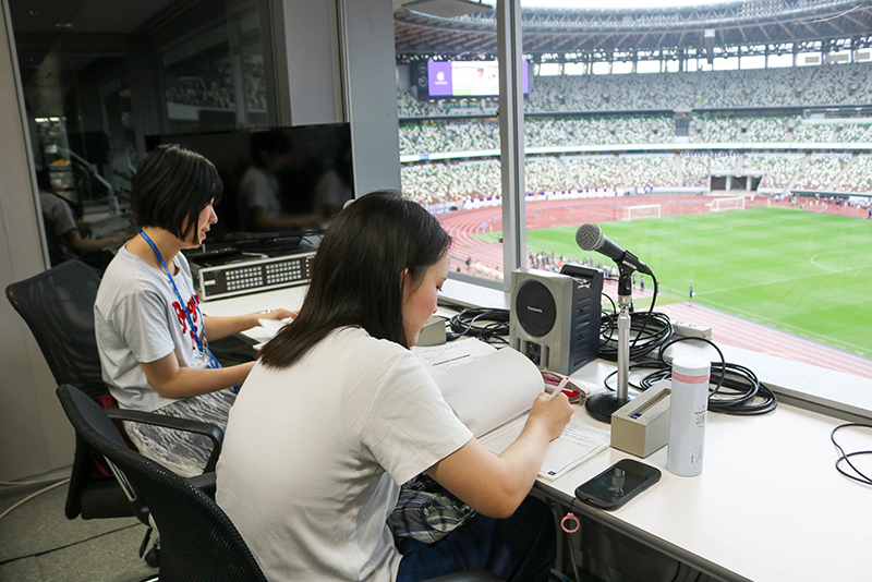 アナウンスブースで原稿チェック