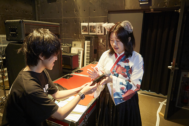 舞台袖では、音響技術科の学生がdreaming catsのメンバーにマイクを渡す場面も!