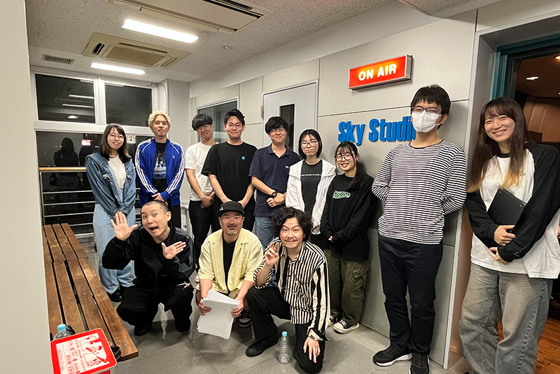 <p>マツモトクラブさん、国崎和也さん（ランジャタイ）、構成作家・山下サトシさんと一緒に東放学園専門学校のラジオスタジオ「Sky Studio」前で集合写真</p>